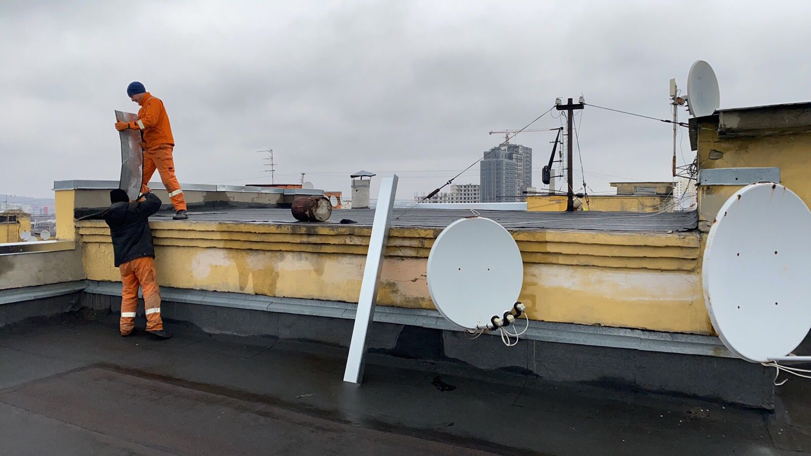 Відновлюють дах будинку на Основі комунальники Харкова